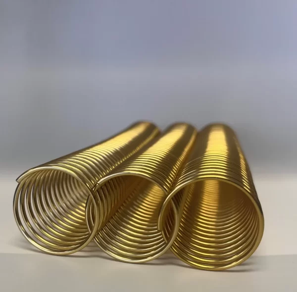 A single piece of 1+3/8" x10" #4 PEL Gold Solid Spiral Aluminum is displayed, featuring three golden metal coils aligned horizontally against a light surface with a neutral background.