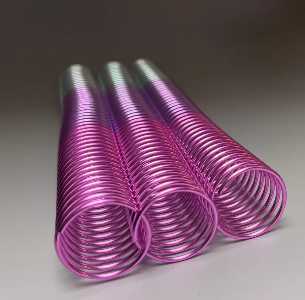 A single 30mm x 11" #4 Passion Rainbow Coil in a metallic pink hue rests on a plain surface.