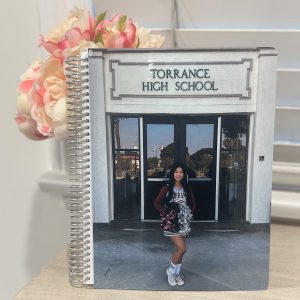 A Custom Notebook featuring a personalized cover with a photo of a cheerleader in front of Torrance High School.