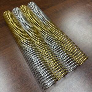 A single 1+1/2″ x12″ #4 Twinkle Multicolor Coil is displayed on a brown wooden surface.