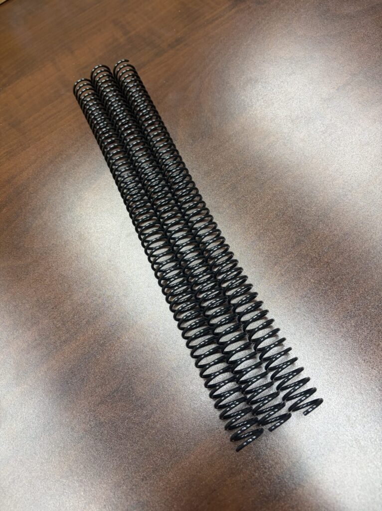 Three 5/8″ x12″ #4 Black Spiral Plastic binding coils arranged vertically.