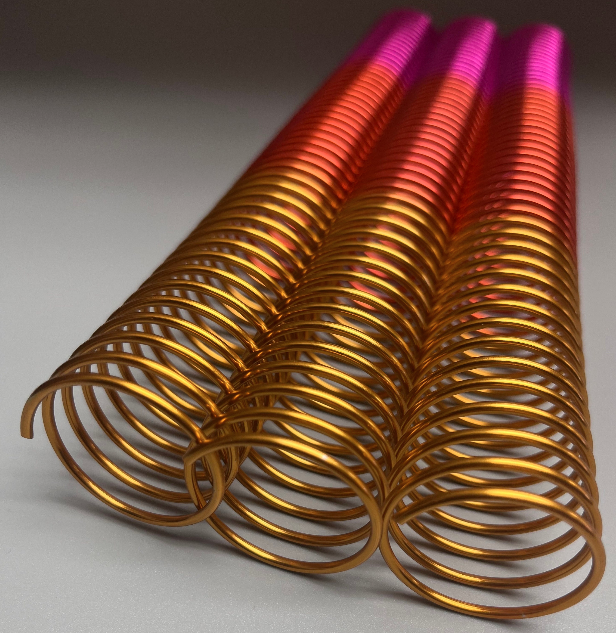 Three 1+1/4″ x12″ #4 Remix Peach wire binding coils with a gradient transition from gold to red to pink.